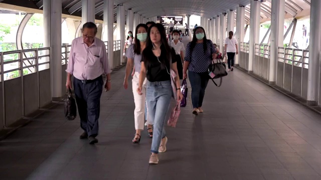 泰国曼谷，在病毒爆发和PM2.5空气污染危机高峰时段，人群戴着防护口罩视频素材