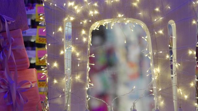 礼盒和节日灯光在橱窗里，夜晚街灯反射视频下载