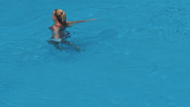 一个女人在蓝色的水池里游泳视频下载