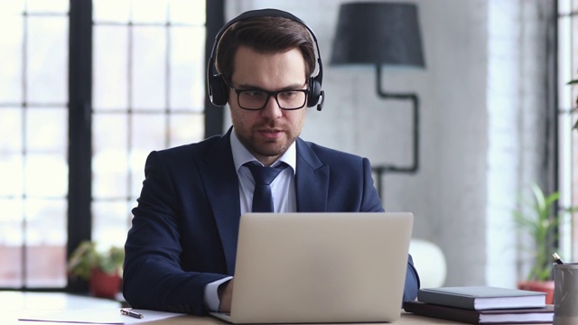 自信的商人戴着耳机在笔记本电脑上进行视频会议视频素材