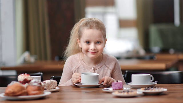 有趣好玩的女孩喝茶舔嘴有积极的情绪。红色摄像机中拍摄视频素材