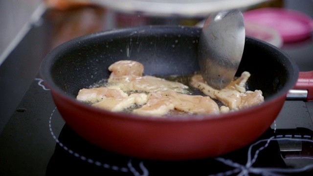 特写:在热锅中用慢动作加热油和炸鸡。视频素材