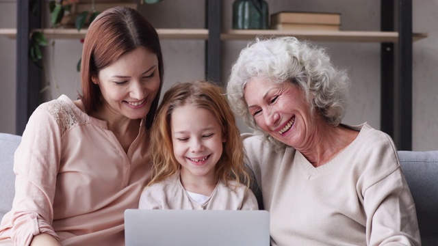 三代妇女一家人在笔记本电脑上看有趣的视频视频素材