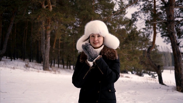 年轻美丽的女人在冬天的森林里行走的肖像视频下载