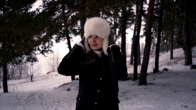 时尚少女在冬天的时候。穿透森林散步视频下载