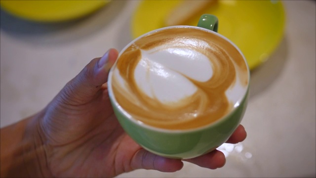 咖啡师用豆奶在咖啡上画拉花艺术。咖啡店制作素食无乳糖饮料的过程。专业的咖啡师。视频素材