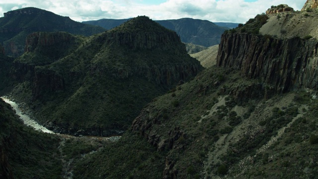 戏剧性的悬崖高耸在盐河峡谷与水远低于无人机射击视频下载