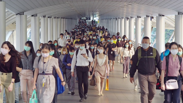 4K分辨率的亚洲人群在早高峰时间在曼谷上班时戴着防冠状病毒或新冠病毒防护面罩和空气中的微尘pm 2.5视频下载