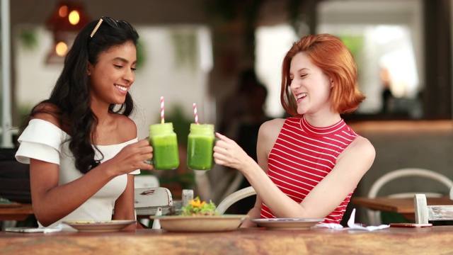 多文化的朋友用绿色果汁干杯。多种族的年轻女性喝健康的蔬菜汁视频素材
