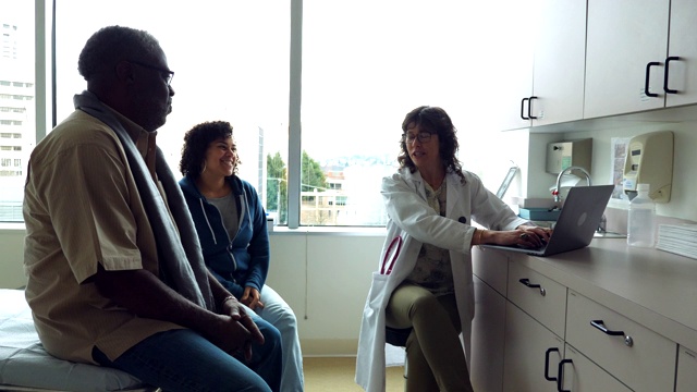 微笑的女医生在检查室与年长的男病人和成年的女儿讨论视频下载