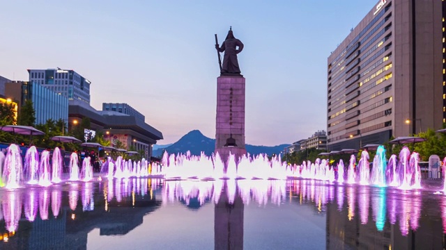 游客在韩国首尔市光华门广场参观彩色地板喷泉和海军上将李舜臣雕像视频下载