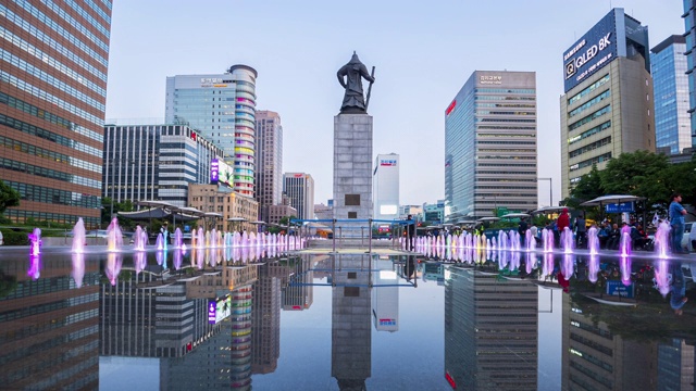 游客在韩国首尔市光华门广场参观彩色地板喷泉和海军上将李舜臣雕像视频素材