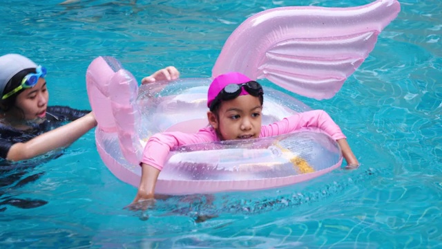 暑假亚洲家庭旅游度假派对在度假村的游泳池小女孩享受游泳和玩得愉快视频下载