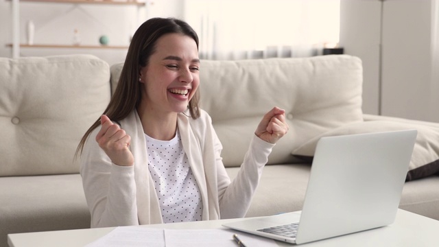 快乐女生在家用笔记本电脑庆祝网络成功视频素材