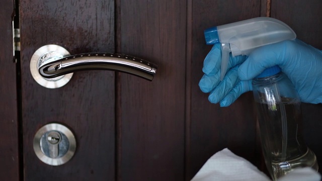 消毒表面细菌或病毒的概念，用消毒剂手清洁门把手。视频下载