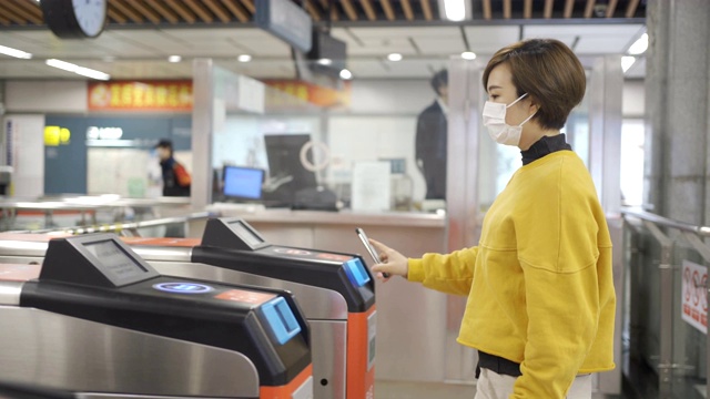 一名年轻的亚洲女子在智能手机上使用app设备为地铁买单视频素材