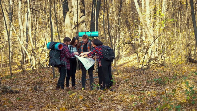 徒步旅行者在秋天的森林里看纸质地图视频下载