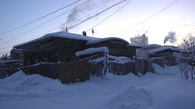 西伯利亚萨哈，夕阳西下的雅库茨克历史中心，古老的木屋与被雪覆盖的现代木板之间视频素材
