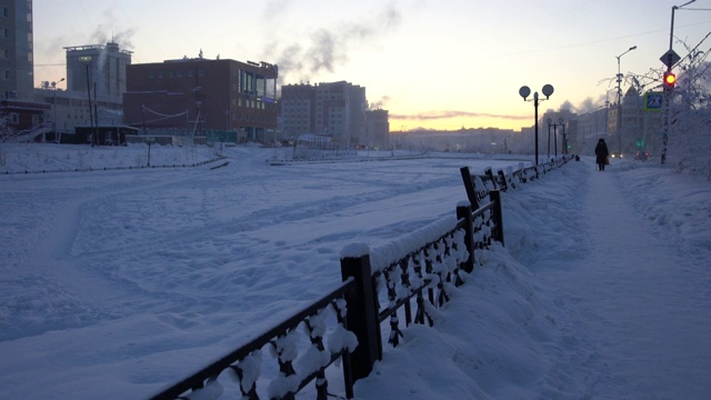 日落时分，西伯利亚萨哈市雅库茨克市发电厂的烟管释放出的烟雾视频素材