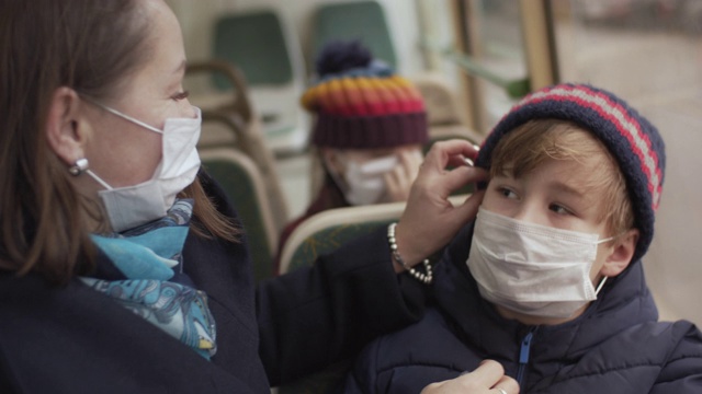 家人在公共汽车上戴着医用防护口罩视频素材