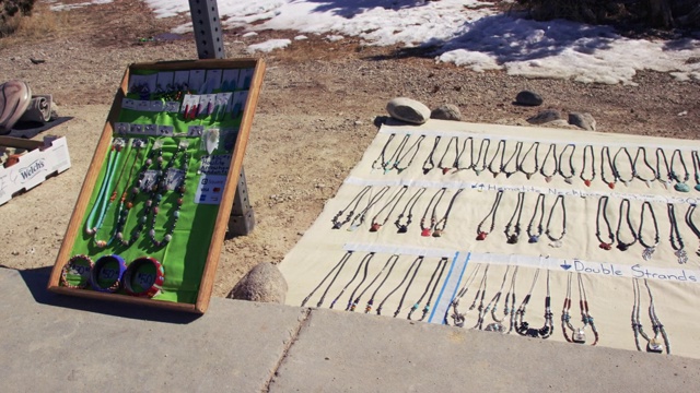 多莉拍摄的本土美国风格的珠宝和陶器展示户外购买在一个阳光明媚的日子，在冬天的雪地上视频下载