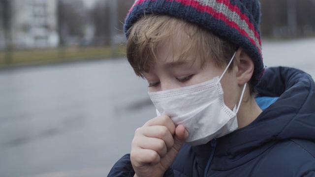 小男孩戴着医用防护口罩咳嗽视频素材