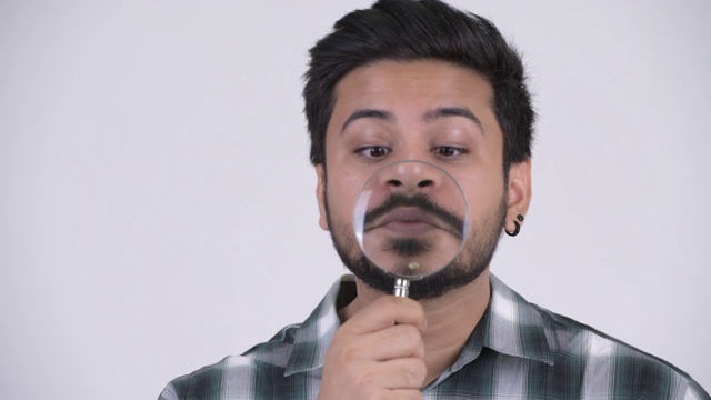 滑稽的长着胡子的年轻印度嬉皮士，戴着放大镜视频下载