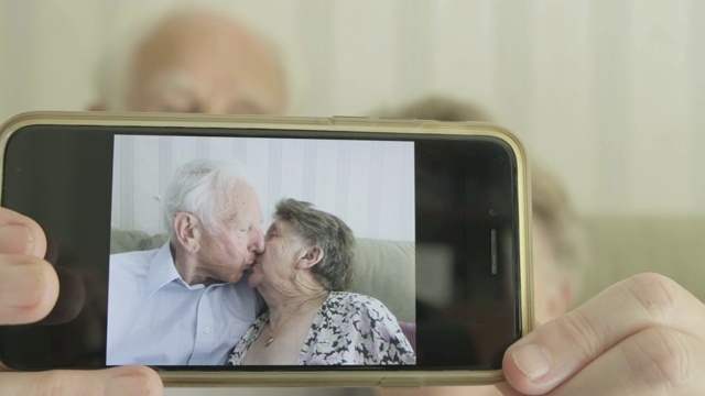 一对老年夫妇拿着智能手机对着摄像头视频下载