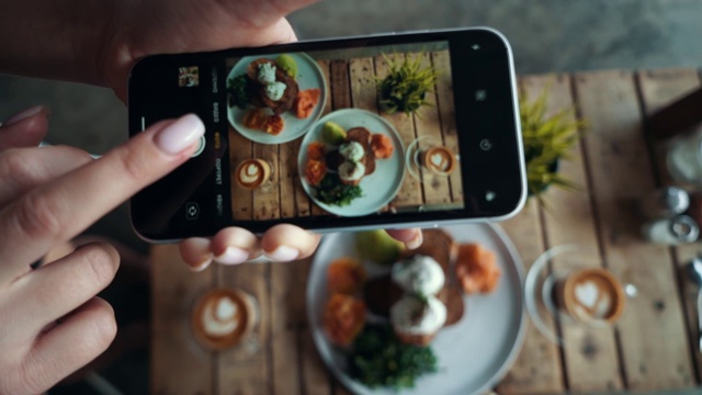 在餐厅里，女性用智能手机拍摄美食。印尼巴厘岛的传统早餐视频下载