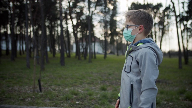戴着防毒面具的小男孩在公园里散步视频素材