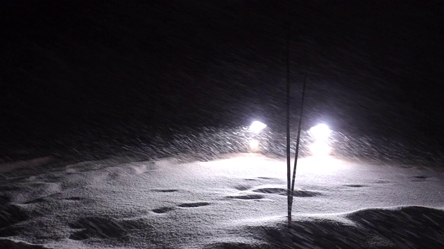 冬天驾驶雪在晚上在深雪风暴-汽车的前灯做一个转弯和开车离开视频素材
