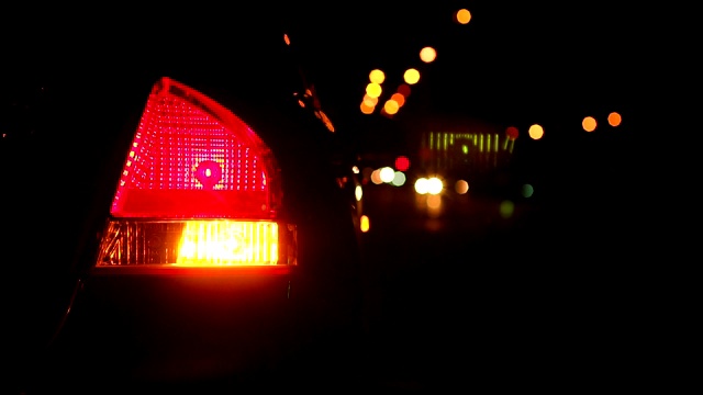 特写闪烁的黄色尾灯在晚上的汽车。缓慢的运动。视频素材