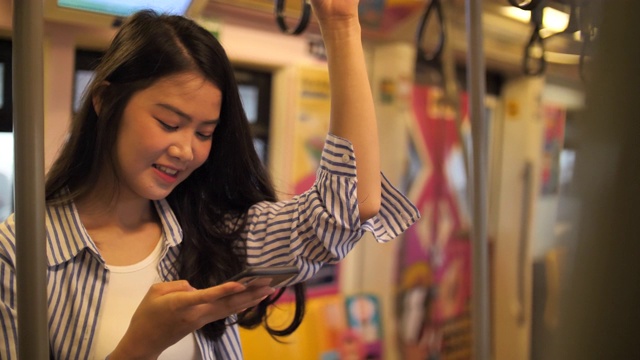 女性在公共交通工具上使用智能手机视频素材