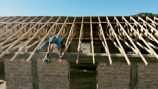 在新建筑的屋顶上工作的木匠视频下载