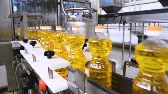 葵花籽油的瓶子在生产线上移动。葵花油制品厂视频下载