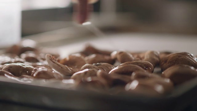 在商业厨房里，专业厨师在烤盘上给蘑菇滴油视频下载