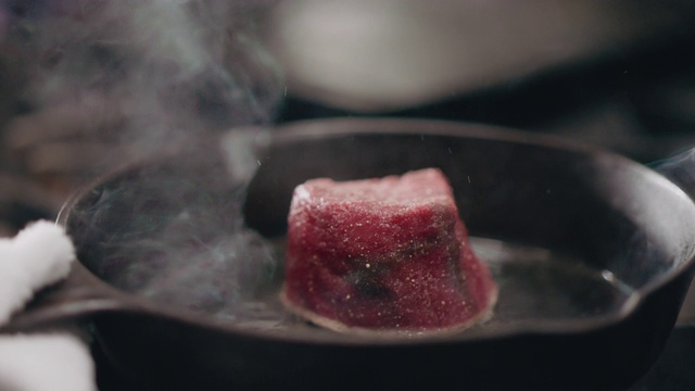 SLO MO:专业厨师在铸铁平底锅中烹饪生牛排视频素材