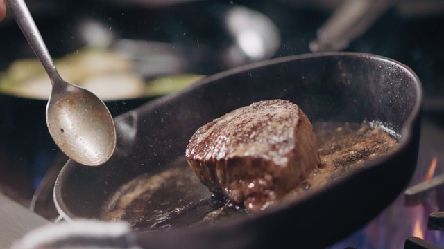 专业厨师在铸铁锅中烹饪牛排时加入食用油视频素材