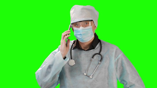 年轻医生在医疗口罩和防护服通话。在Chrome Key的背景上拍摄。铬凯高品质视频素材
