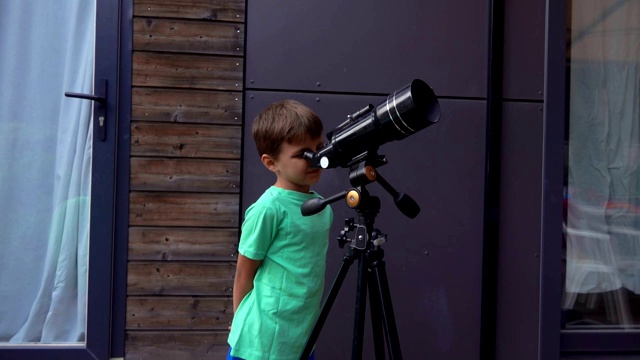 夏日里，一个快乐的小男孩用望远镜观察天空视频下载