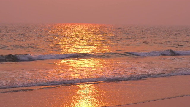 阳光从日落的海滩风景在潮湿的沙子和海浪视频素材