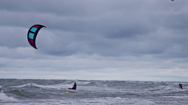 缓慢的运动。人们在海里玩风筝冲浪视频下载