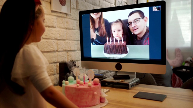 生日女孩吹生日蜡烛，而她的家人通过视频应用程序唱她的生日歌视频下载