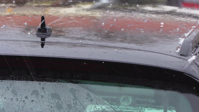站在外面的一辆车的车顶上，冰雹和雨水在浅浅的下落和跳跃视频下载
