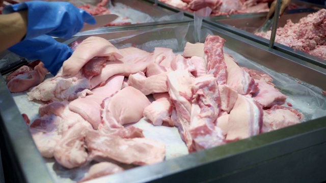 屠夫在超市切猪肉。视频素材