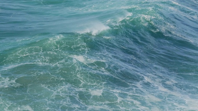 海浪从海洋上升起，产生白色泡沫并溅起水花视频素材