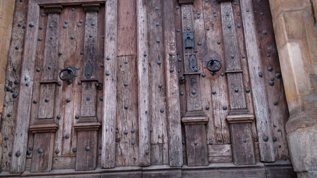 特写关闭两个古老的木质门与金属把手在古代中世纪天主教教堂。视频素材