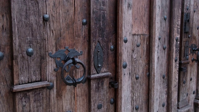 古中世纪天主教教堂中带有金属把手的旧木门的特写。视频素材