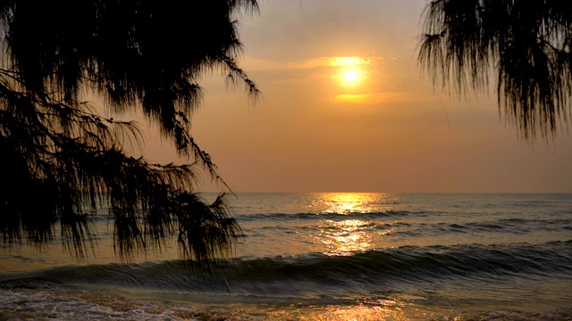日落时海浪卷起白色沙滩的慢镜头视频素材