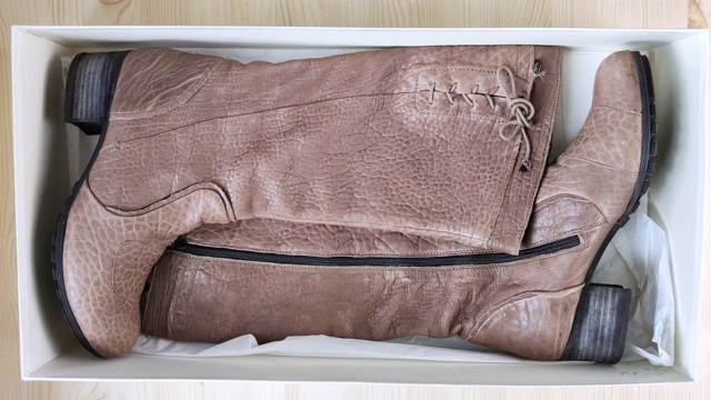 棕色的女靴躺在白色的盒子里。从打开的盒子里拿出后跟的皮鞋视频下载